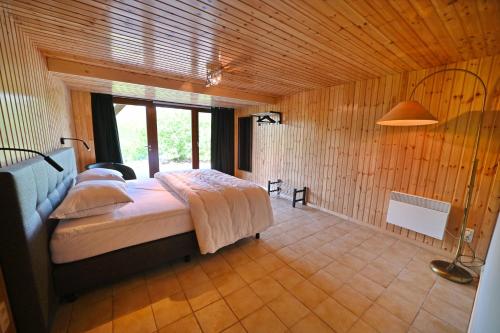 a bedroom with a bed in a room with wooden walls at River View in Rendeux