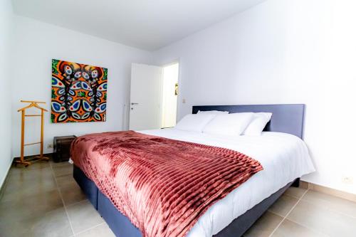 a bedroom with a large bed with a red blanket at Laluna holiday apartment in Ostend