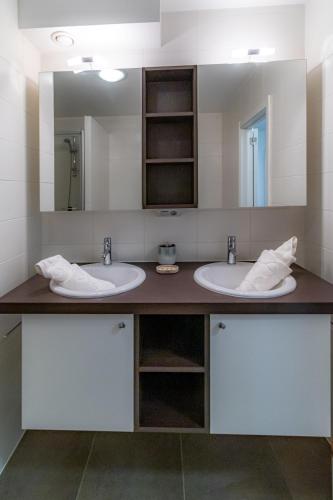 a bathroom with two sinks and a large mirror at Laluna holiday apartment in Ostend