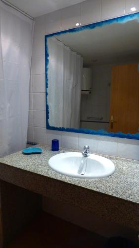 a bathroom counter with a sink and a mirror at Espalmador 19 in Es Pujols
