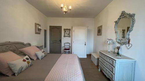 a bedroom with a bed and a mirror and a dresser at TENDANCE CAMPAGNE Chambre d'hôtes in Marillac