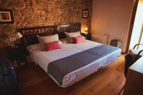 a bedroom with a large bed with red pillows at Torres de Moreda in A Estrada