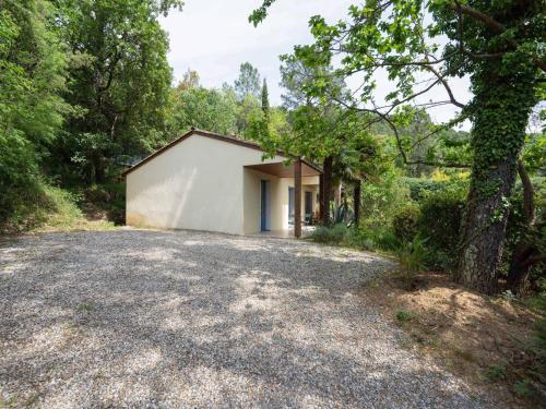 a house in the woods with a gravel driveway at Family Escape in Les Salelles in Chambonas