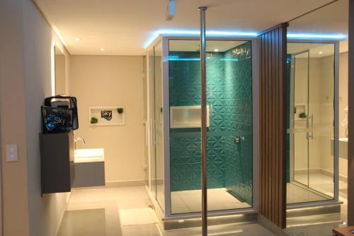 een douche in een badkamer met een groene muur bij Sky Motel Itaqua in Itaquaquecetuba