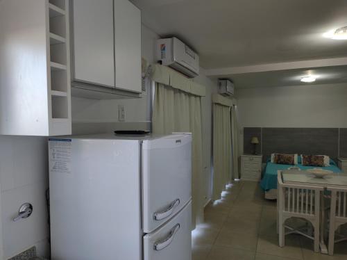 a kitchen with a white refrigerator and a table at Altos del Boulevard in Santiago del Estero