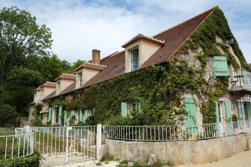 Chevroches的住宿－Le Domaine des Carriers，常春藤覆盖的房子,有白色的围栏