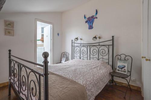 een slaapkamer met een bed met een smeedijzeren bedframe bij Petit Paradis Nemausus in Nîmes