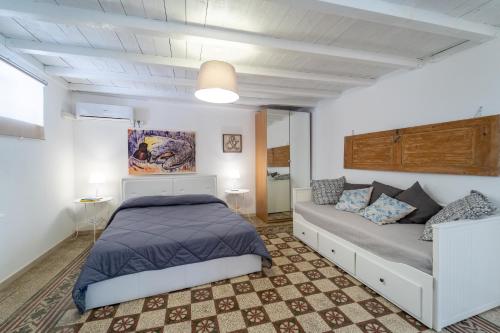 シラクーサにあるCasa Talete Cozy Apartment in Ortigia - FIRST FLOORのベッドルーム(ベッド1台、ソファ付)