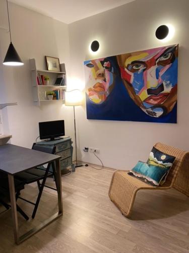 una sala de estar con una mesa y una pintura en la pared en Artist apartment centro storico, en Perugia