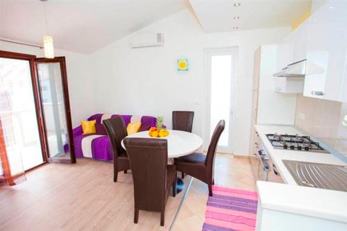 a kitchen and dining room with a table and chairs at Apartmani Centar Makarska in Makarska