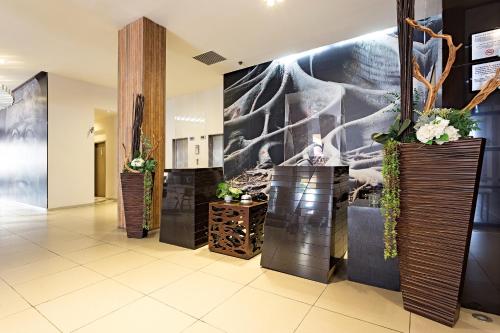 a lobby with three vases with flowers on the wall at Gamma Villahermosa Centro in Villahermosa