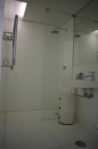 a white bathroom with a sink and a mirror at Nova Casa com Piscina no Convento das Bernardas in Tavira
