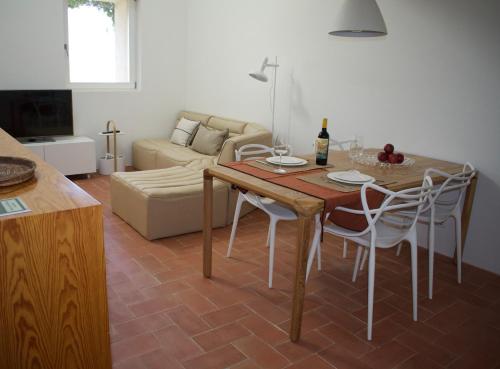 a living room with a table and chairs and a couch at Nova Casa com Piscina no Convento das Bernardas in Tavira
