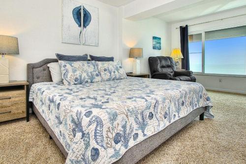 a bedroom with a bed and a chair and a window at Shore House 502 in Clearwater Beach