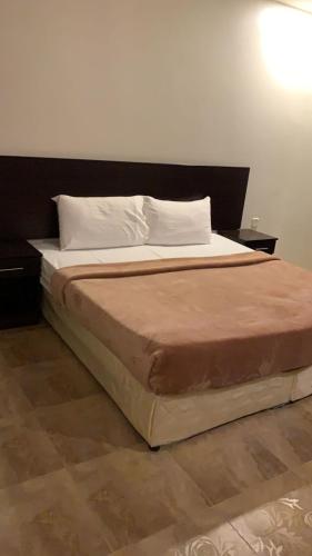 a bed in a room with two nightstands and a bed sidx sidx sidx at نسيم البحر in Yanbu