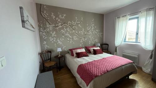 a bedroom with a large bed with red pillows at TENDANCE CAMPAGNE Chambre d'hôtes in Marillac