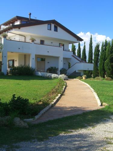 a large white house with a path in front of it at B&B Radici24 in Battipaglia