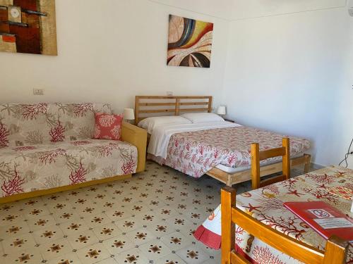 ein Wohnzimmer mit 2 Betten, einem Sofa und einem Sofa in der Unterkunft Ponzamania Casa Silvana Ponza in Ponza