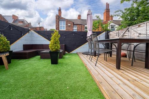 a backyard with a wooden deck and grass at Stunning Victorian House in Hull