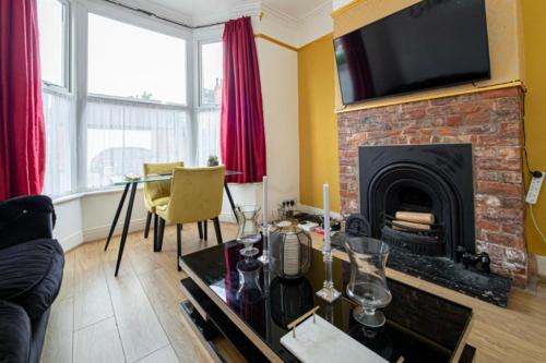 a living room with a fireplace with a television on top at Stunning Victorian House in Hull