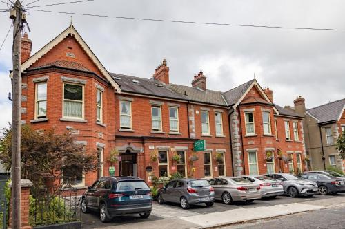 un gran edificio de ladrillo con coches estacionados frente a él en Egans House, en Dublín