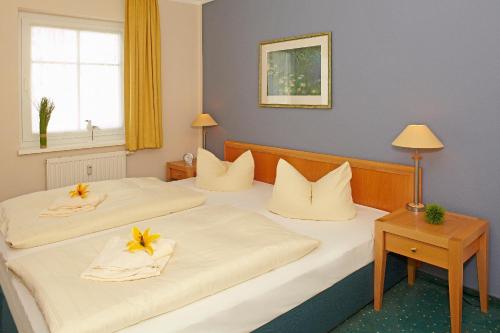 - 2 lits dans une chambre d'hôtel avec des fleurs sur les oreillers dans l'établissement Inselstrand Inselstrand 216, à Ahlbeck