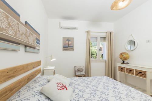 a bedroom with a bed and a desk and a window at Appartamenti Nonna Rosa in Santa Maria Navarrese