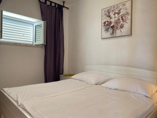 1 dormitorio con 1 cama blanca y ventana en APARTMENT YVONE en Zavalatica