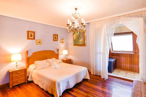 um quarto com uma cama e um lustre em Vistas increíbles! a 3 minutos de la playa con Wifi em Santander