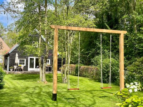 a swing set in the yard of a house at Gastenverblijf Oostdijk in Goedereede