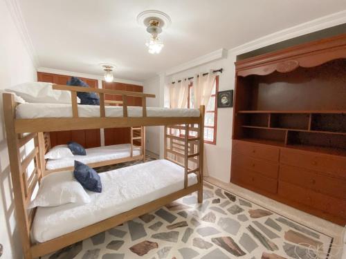 a room with three bunk beds and a television at Hotel Cabañas Villa Roca, Rodadero in Santa Marta