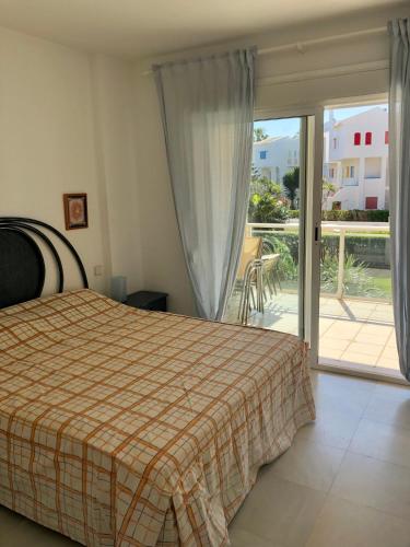 a bedroom with a bed and a sliding glass door at Apartamento de playa in Denia