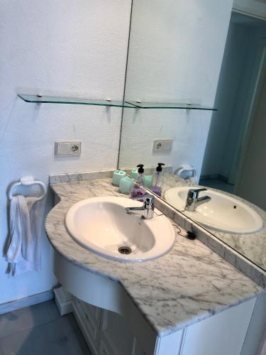 a bathroom with two sinks and a large mirror at Apartamento de playa in Denia