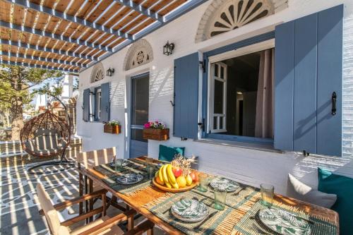 a table with a bowl of fruit on a patio at Θἔρως (Theros) house 3- Agios Fokas in Agios Sostis