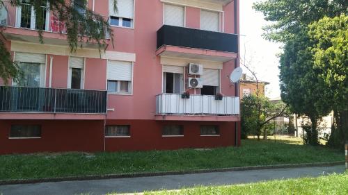um edifício cor-de-rosa com uma varanda e um satélite em Appartamento Intero Bilocale Totalmente Arredato A Padova em Pádua