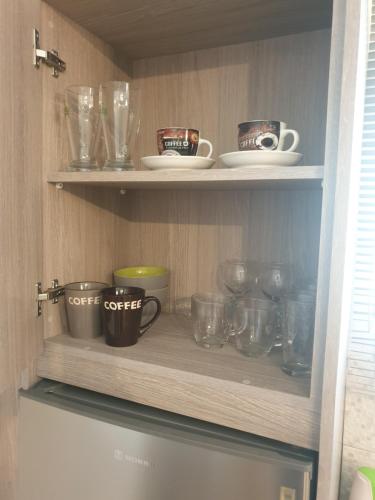 a cupboard filled with lots of cups and bowls at blue - comfy center rodos in Asgourou