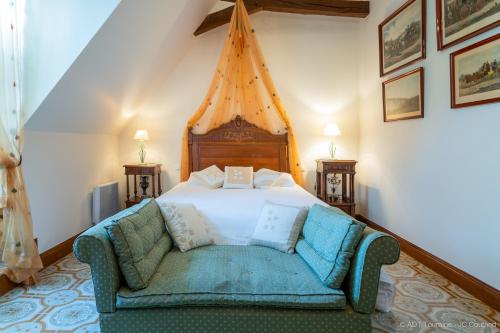 a bedroom with a bed and a couch in it at Le vieux château de Hommes in Hommes