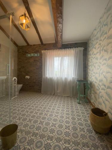 a bathroom with a shower and a tub and a window at Casa Meiga in Arzúa