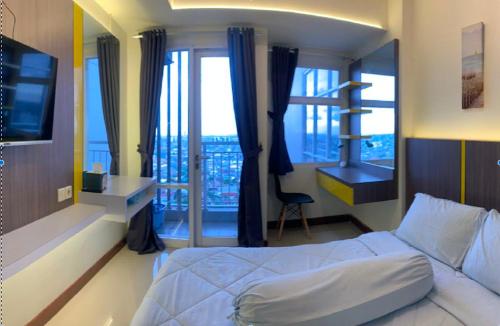 a bedroom with a bed and a view of a city at Vidaview Brenstville Tower in Makassar