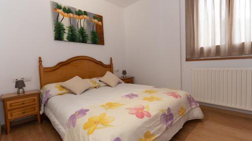 Un dormitorio con una cama con flores. en Montmalus Soldeu, en Soldeu