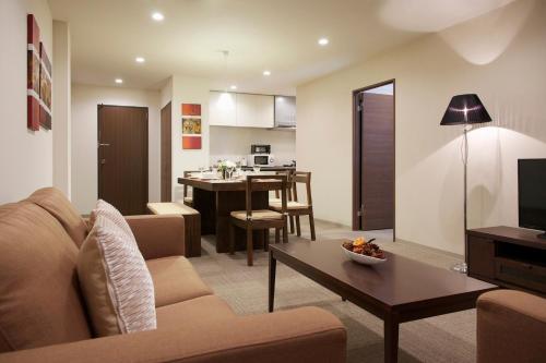 a living room with a couch and a dining room at Hakuba Grand Apartments in Hakuba