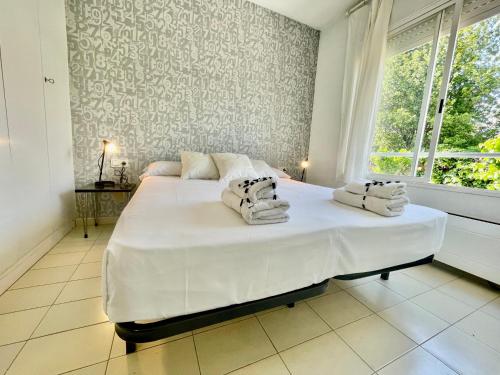 a bedroom with a large white bed with towels on it at LOVELY LOFT IN SITGES by hlclub HUTB-11931 SOC in Sitges