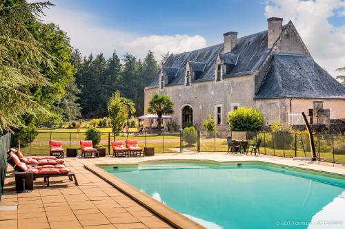 una finca con piscina frente a una casa en Le vieux château de Hommes, en Hommes