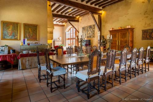 a dining room with a long table and chairs at Le vieux château de Hommes in Hommes