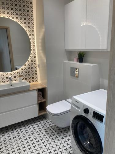uma casa de banho branca com uma máquina de lavar roupa em Rakowicka Modern Apartment na Cracóvia