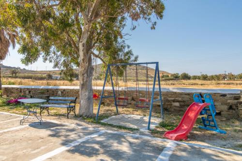a playground with a bench and a swing at Θἔρως (Theros) house 3- Agios Fokas in Agios Sostis