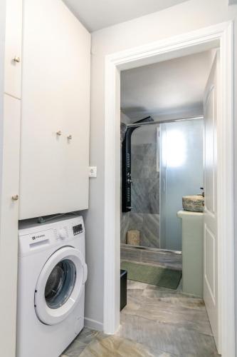 a laundry room with a washer and dryer at Θἔρως (Theros) house 3- Agios Fokas in Agios Sostis