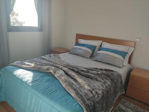 a bed with a blanket on it in a bedroom at Casa do Iteiro in Caniçada