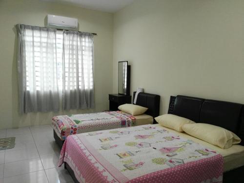 a room with two beds and a window at Fong's Ipoh SImpang Pulai Homestay in Ipoh