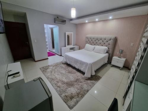 a bedroom with a white bed and a mirror at Tourist House in Santa Cruz de la Sierra